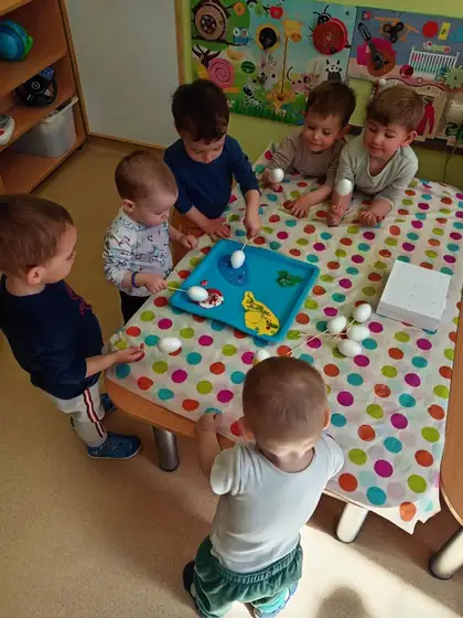 Mališani iz jaslene grupe boje bela jaja nataknuta na štapiće