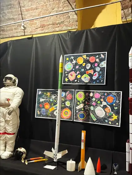 Postavka u muzeju svemira: skafander, makete raketa i dečji crteži planeta
